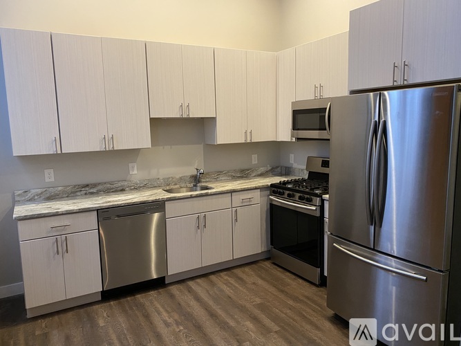 A kitchen with white cabinets and a stainless steel refrigerator.