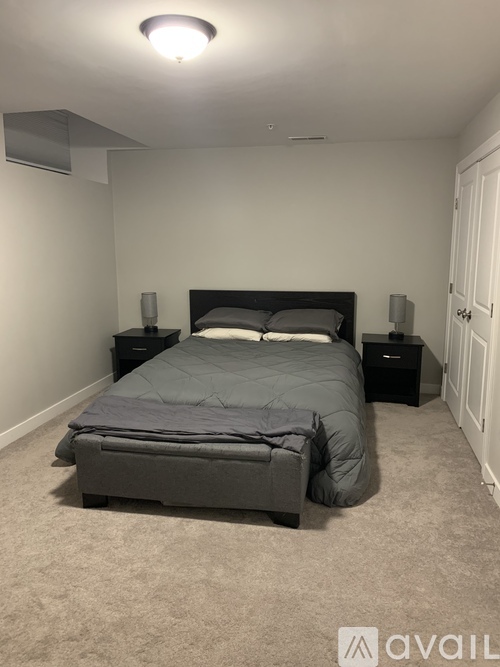 A bedroom with a bed, nightstands, and a carpeted floor.