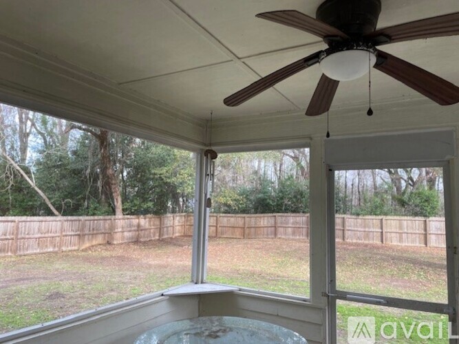 A patio with a ceiling fan and a hot tub.