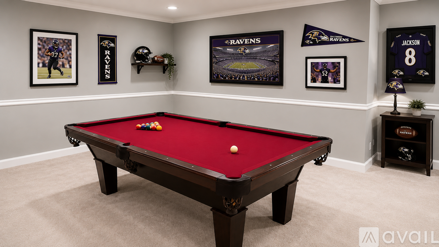 A pool table in a room with a carpeted floor and walls decorated with Baltimore Ravens memorabilia.