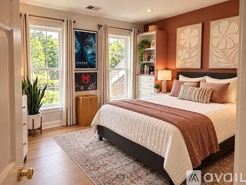 A bedroom with a large bed and a poster of Avatar on the window.
