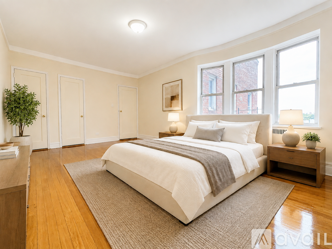 A bedroom with a large bed and a plant on the side table.