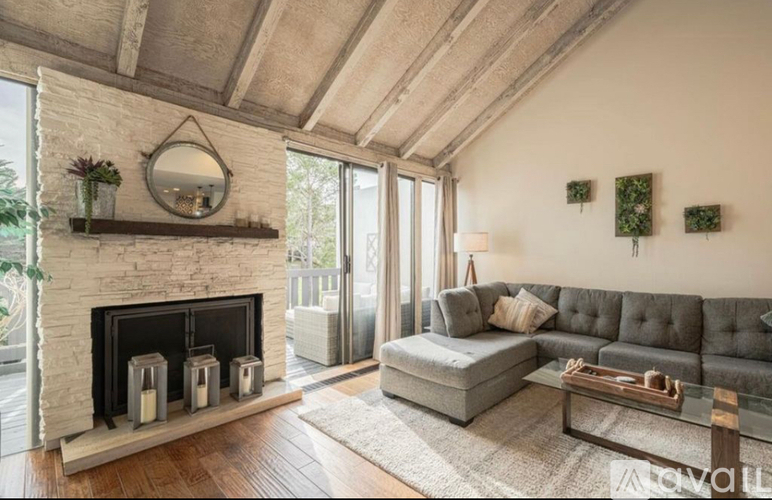 A modern living room with a grey sofa and a fireplace.