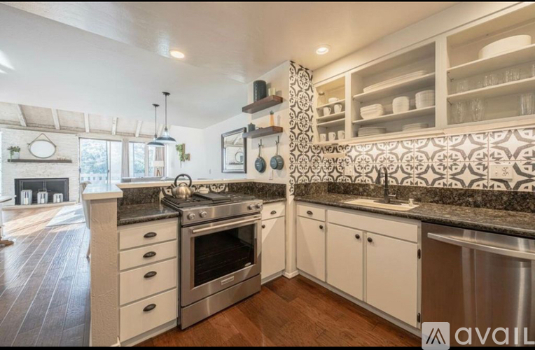 A kitchen with a black countertop and white cabinets.