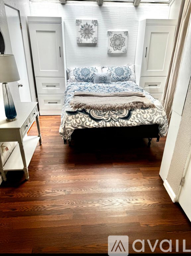 A bedroom with a bed, nightstand, and lamp.
