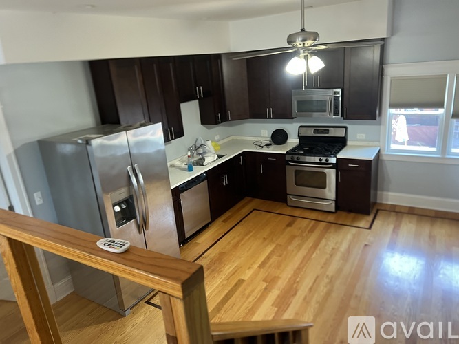 A kitchen with wooden floors and stainless steel appliances.