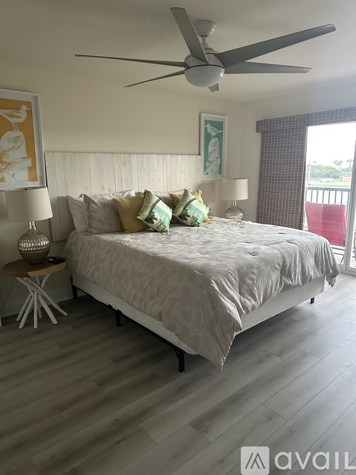 A bedroom with a large bed and a ceiling fan.