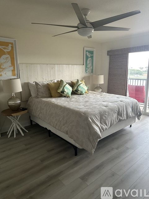 A bedroom with a large bed and a ceiling fan.