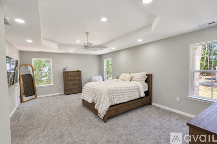 A bedroom with a large bed and a ceiling fan.