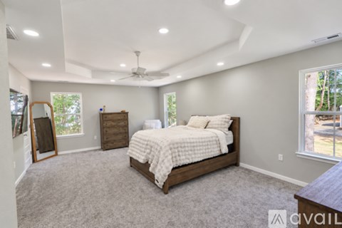 A bedroom with a large bed and a ceiling fan.