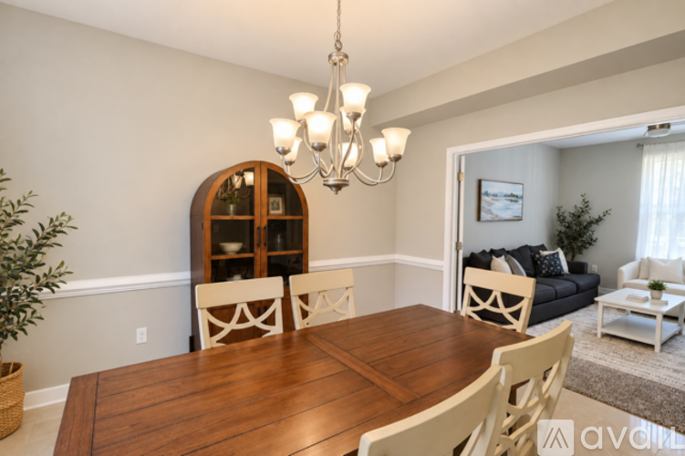 A dining room with a wooden table and chairs.