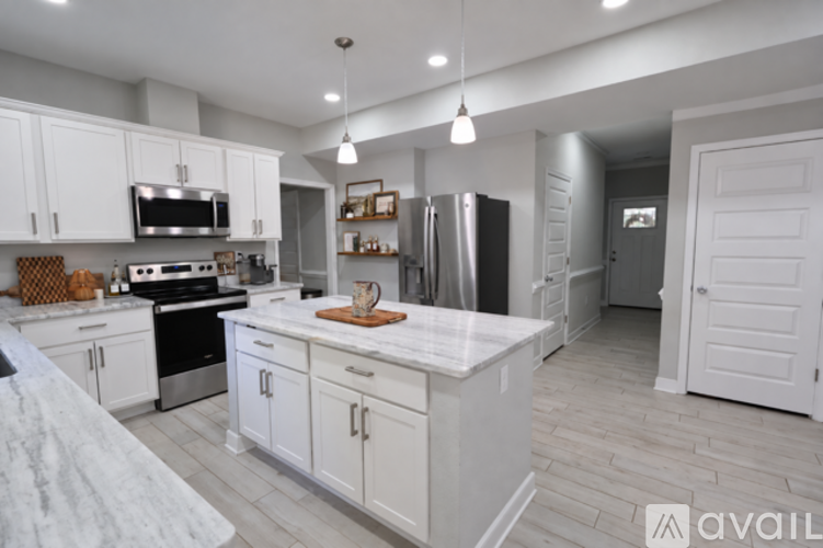 A kitchen with white cabinets and a marble countertop.