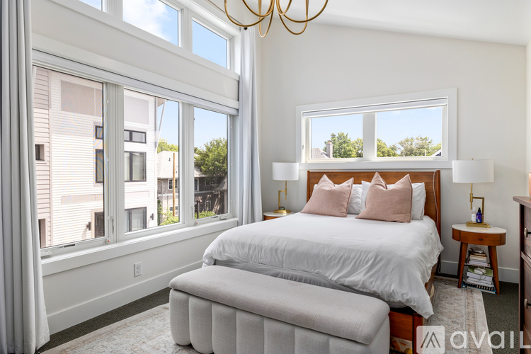 A bedroom with a large bed and a chandelier.