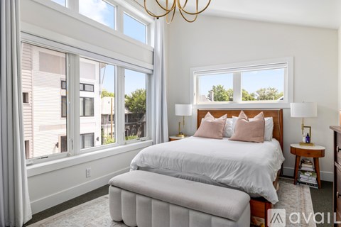 A bedroom with a large bed and a chandelier.