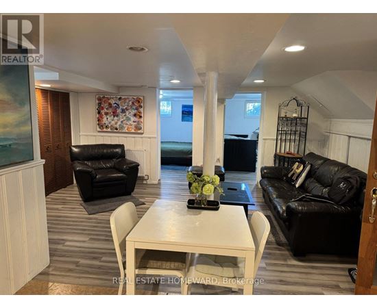 A living room with a white table and black leather couches.