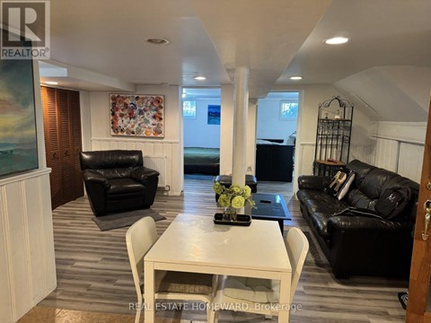 A living room with a white table and black leather couches.