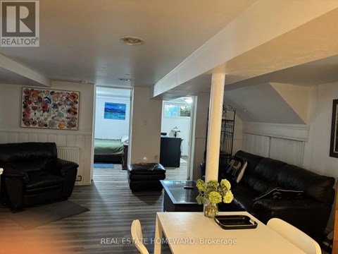 A living room with a couch, a coffee table, and a vase of flowers.