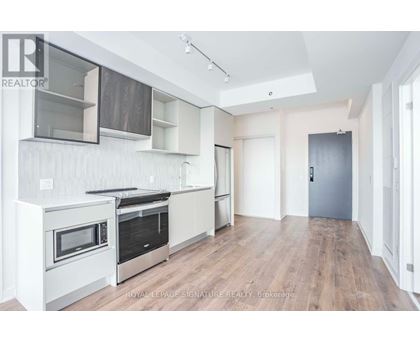 A modern kitchen with white cabinets and stainless steel appliances.