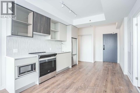 A modern kitchen with white cabinets and stainless steel appliances.