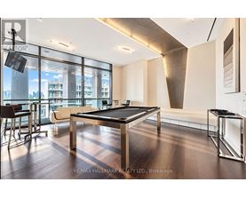 A room with a pool table and a view of the city.