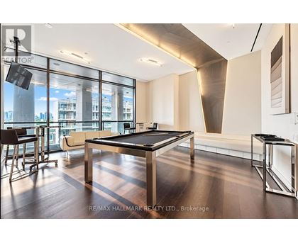 A room with a pool table and a view of the city.