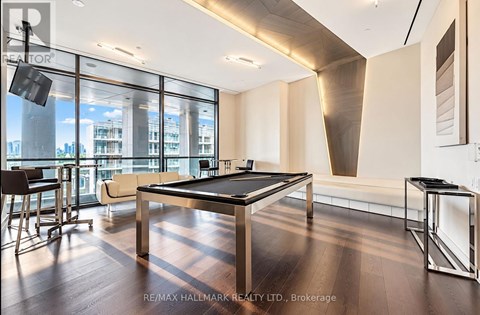 A room with a pool table and a view of the city.