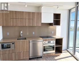 A modern kitchen with wooden cabinets and stainless steel appliances.