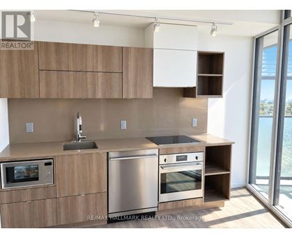A modern kitchen with wooden cabinets and stainless steel appliances.
