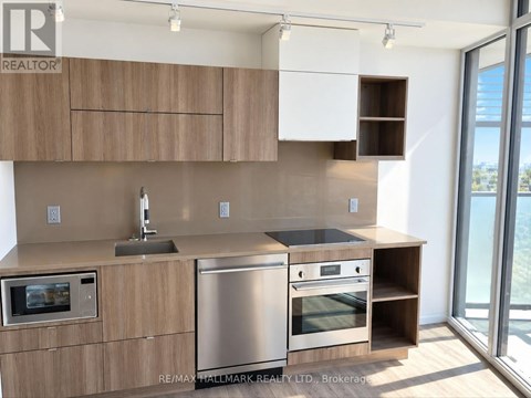 A modern kitchen with wooden cabinets and stainless steel appliances.
