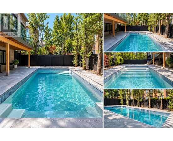 A swimming pool surrounded by a black fence and trees.