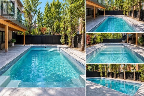 A swimming pool surrounded by a black fence and trees.