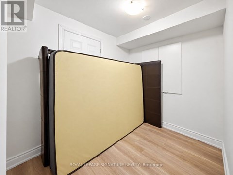 A room with a yellow wall and a wooden floor.
