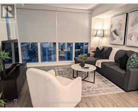 A living room with a grey couch, a white chair, and a coffee table.