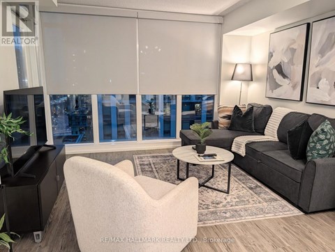 A living room with a grey couch, a white chair, and a coffee table.