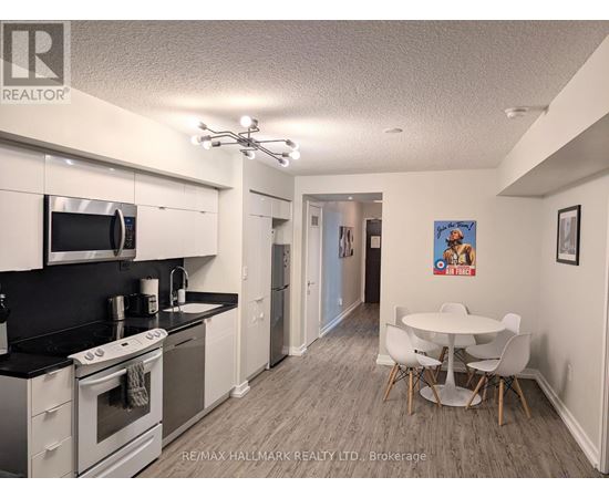 A kitchen with white cabinets and a black countertop.