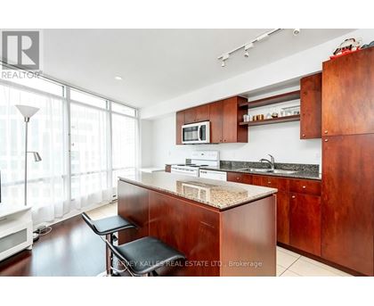 A kitchen with dark wood cabinets and a granite countertop.