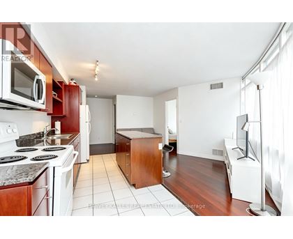 A kitchen with white appliances and a white stove top oven.