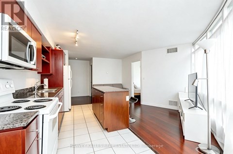 A kitchen with white appliances and a white stove top oven.