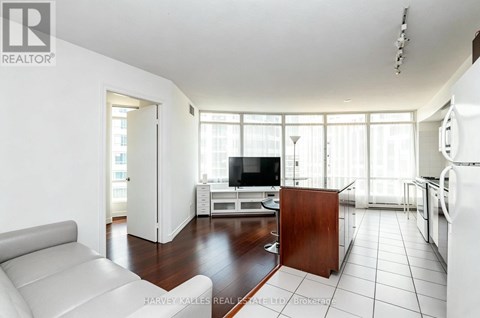 A living room with a white couch and a television.