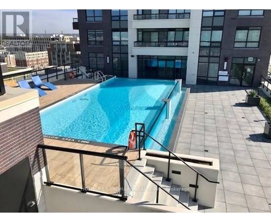 A swimming pool on a rooftop with a glass railing.