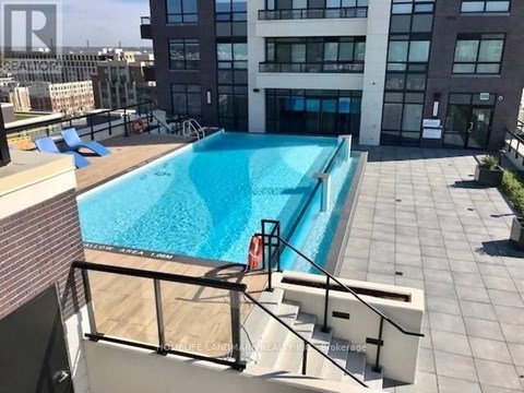 A swimming pool on a rooftop with a glass railing.