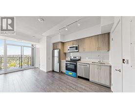 A kitchen with a refrigerator, oven, and microwave.