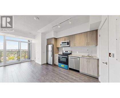 A kitchen with a refrigerator, oven, and microwave.