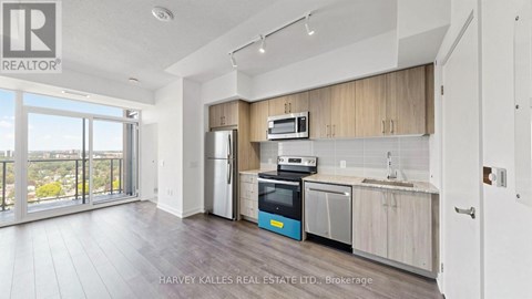 A kitchen with a refrigerator, oven, and microwave.