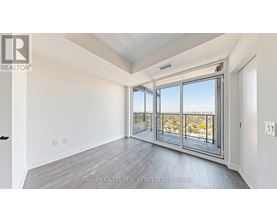 A spacious room with a view of the outdoors through large windows.