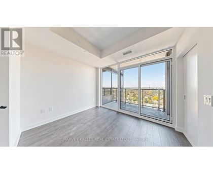 A spacious room with a view of the outdoors through large windows.
