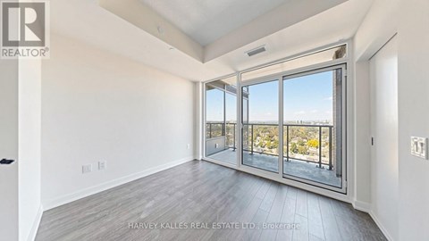 A spacious room with a view of the outdoors through large windows.