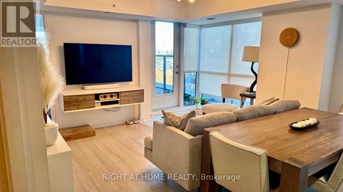 A modern living room with a flat screen TV and a wooden coffee table.