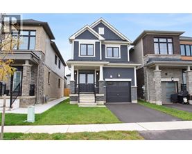 A large, modern house with a black front door and a garage.