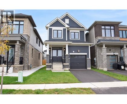 A large, modern house with a black front door and a garage.
